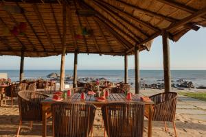 a table with chairs on the beach with the ocean at The Park Visakhapatnam in Visakhapatnam