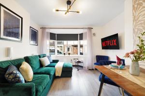 a living room with a green couch and a table at 30 percent off! Stylish Yorkshire Apartment - Sleeps 5 in Castleford