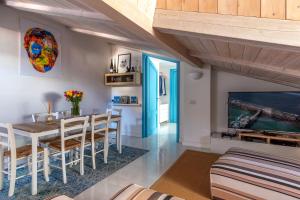 a living room with a dining room table and a tv at Mansarda del Corso in Sorrento