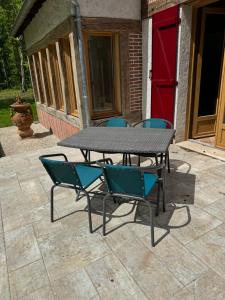 a picnic table and four chairs on a patio at Maison pour vacances ou fêtes de famille L'Orée de Clénord in Mont-près-Chambord