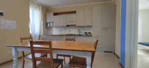 a kitchen with a wooden table and chairs in a room at Villaggio Mietta in Castiglioncello