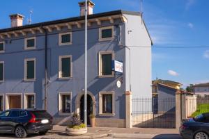 a blue building with a car parked in front of it at Residenza Villa Bella 2 in Mozzecane