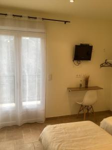 a bedroom with two beds and a tv and a chair at Auberge chez François in Ortale