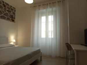 une chambre avec un lit et une fenêtre dans l'établissement LorMar House, à Oristano