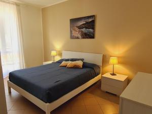 a bedroom with a bed with blue sheets and two lamps at Villaggio Mietta in Castiglioncello +30 photos