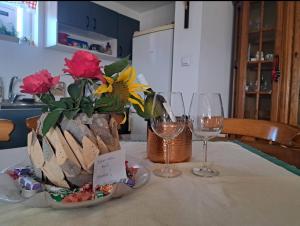 a table with two wine glasses and a vase with flowers at Kuća za odmor "Vila Marina" in Klokočevik