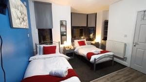 a room with two beds with red and white at Comforatable Modern Studios in Nottingham +68 photos