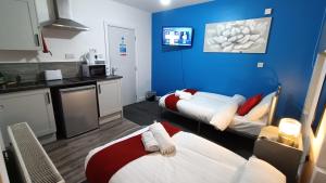a room with two beds and a blue wall at Comforatable Modern Studios in Nottingham