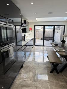 a large kitchen with a wooden table and a dining room at Luxurious Modern House With Garden Close To City Centre in Cardiff