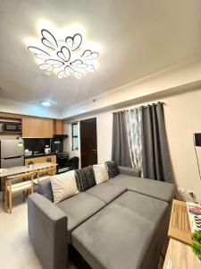 a living room with a gray couch and a kitchen at Cozy Spacious 2BR Unit in Davao City