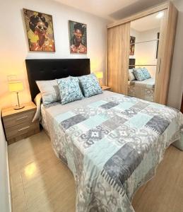 ein Schlafzimmer mit einem großen Bett und einem Spiegel in der Unterkunft La Caleta Holiday Homes in Castillo del Romeral