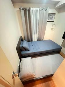 a bed in a room with a curtain at Cozy Spacious 2BR Unit in Davao City