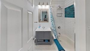 a white bathroom with a sink and a bath tub at Diamond Lakehouse | SUP, Canoe, BBQ, Aurora Magic in Highland Grove +61 photos