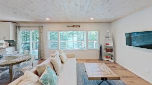 a living room with a white couch and a table at Diamond Lakehouse | SUP, Canoe, BBQ, Aurora Magic in Highland Grove