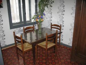 een eettafel met stoelen en een vaas met bloemen bij Le Commerce in Bulgnéville