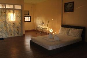 a bedroom with a bed and a table with chairs at Los Ecijanos Inn in Bolinao