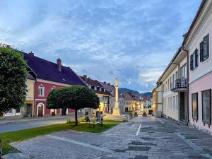 a cobblestone street in a town with a clock tower at Platzfaerberhaus in Obdach