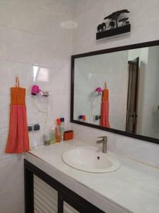 a bathroom with a sink and a mirror at Villa chez ibou somone in Somone