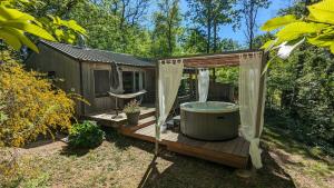 a hot tub on a deck with a gazebo at Lodge Hérisson avec Spa privatif in Biron