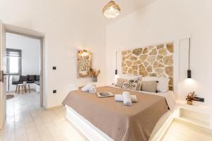 a white bedroom with a large bed with towels on it at Touch Naxos Sunset in Galanado