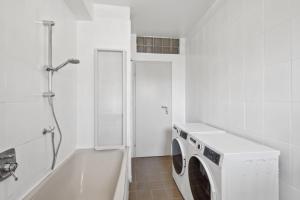 y baño blanco con lavadora y bañera. en MONTEUR - Unterkunft für bis zu 7 Personen in 65479 Raunheim - GG13, en Raunheim 7 fotos más