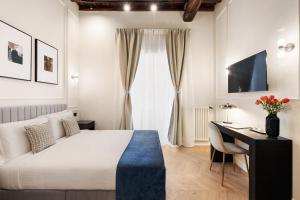 a bedroom with a bed and a desk and a television at Sistina Boutique Guest House in Rome