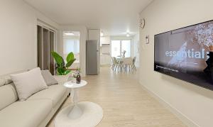 a living room with a white couch and a tv at Gyeongju Florian Stay Close Explore More in Gyeongju