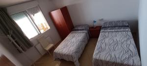 two beds in a small room with a window at Marcotin Piscina playa y montaña in Alcossebre +23 photos
