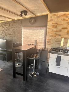 a kitchen with a table and chairs and a stove at Chalet 151 Kniphorst Anloo in Anloo +11 photos