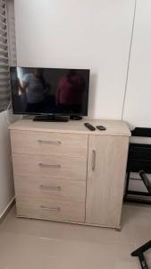 een tv op een houten dressoir bij Apê da divisa in São Vicente