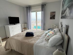 una camera da letto con un letto, una TV e una finestra di Viamare Anzio ad Anzio