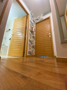 two wooden doors in a room with wooden floors at My 3 stars BEE HAPPY studio in Brides-les-Bains