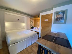 a bedroom with a bed and a table in it at My 3 stars BEE HAPPY studio in Brides-les-Bains