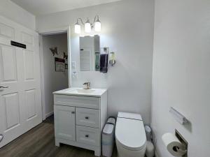 a white bathroom with a toilet and a sink at The Wilderness, Near CP & SF, W&D, Pet OK in Sandusky +20 photos