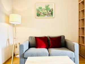 een woonkamer met een bank met twee rode kussens bij Wyndham Garden Sukhumvit 42 in Bangkok