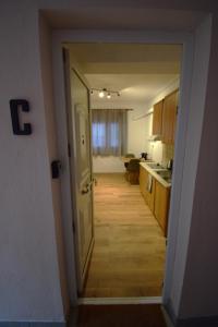 une porte ouverte menant à une cuisine avec couloir dans l'établissement Balkanisateur Studio C, à Kavala 1 autre photo