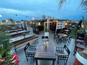 a patio with tables and chairs on a roof at Republica Hostel in San Pedro
