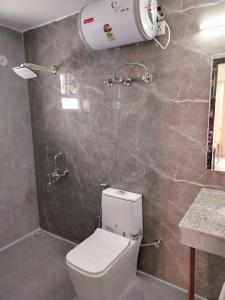 a bathroom with a white toilet and a sink at Shri Rudra's Quad Bed Rooms in Bhowāli