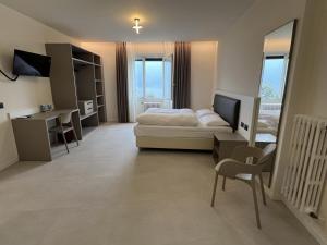 a bedroom with a bed and a desk and a table at Hotel Villa Margherita in Limone sul Garda