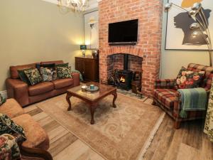 a living room with couches and a brick fireplace at Sunflowers in Whitley Bay