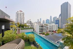 a pool on the roof of a building with a city at Shine Aparthotels Sukhumvit Thonglor in Bangkok