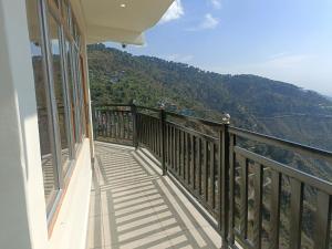 a balcony with a view of a mountain at The village lodge Dalhousie in Banikhet