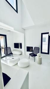 Habitación blanca con 3 sillas y mesa en VotsaLo sea view house, en Kastraki Naxou