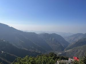 a view of a valley with mountains in the background at The village lodge Dalhousie in Banikhet +7 photos