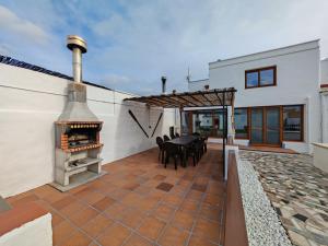 a patio with a pizza oven on the side of a house at Ca la Consol in El Poblenou del Delta