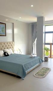 a bedroom with a large bed with a blue comforter at May - 25th Home in Vung Tau +6 photos