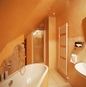 Hotel Sauerländer Hof في هالنغبرغ: حمام مع حوض استحمام ومغسلة