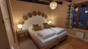 a bedroom with a bed in a wooden wall at Chalet Hulotte avec Spa privatif in Biron