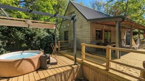 a hot tub on a deck with a house at Chalet Hulotte avec Spa privatif in Biron