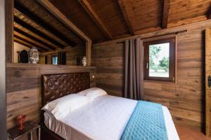 a bed in a wooden room with a window at Tenuta Torre di Pian Castagno in Sutri +44 photos